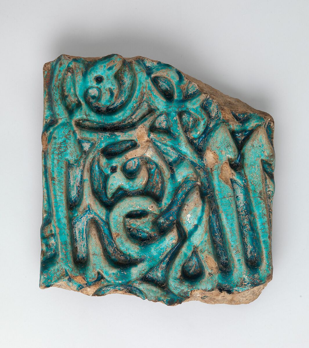 Fragment of a Glazed Tile Inscription, Stonepaste; carved decoration under opaque monochrome glaze 