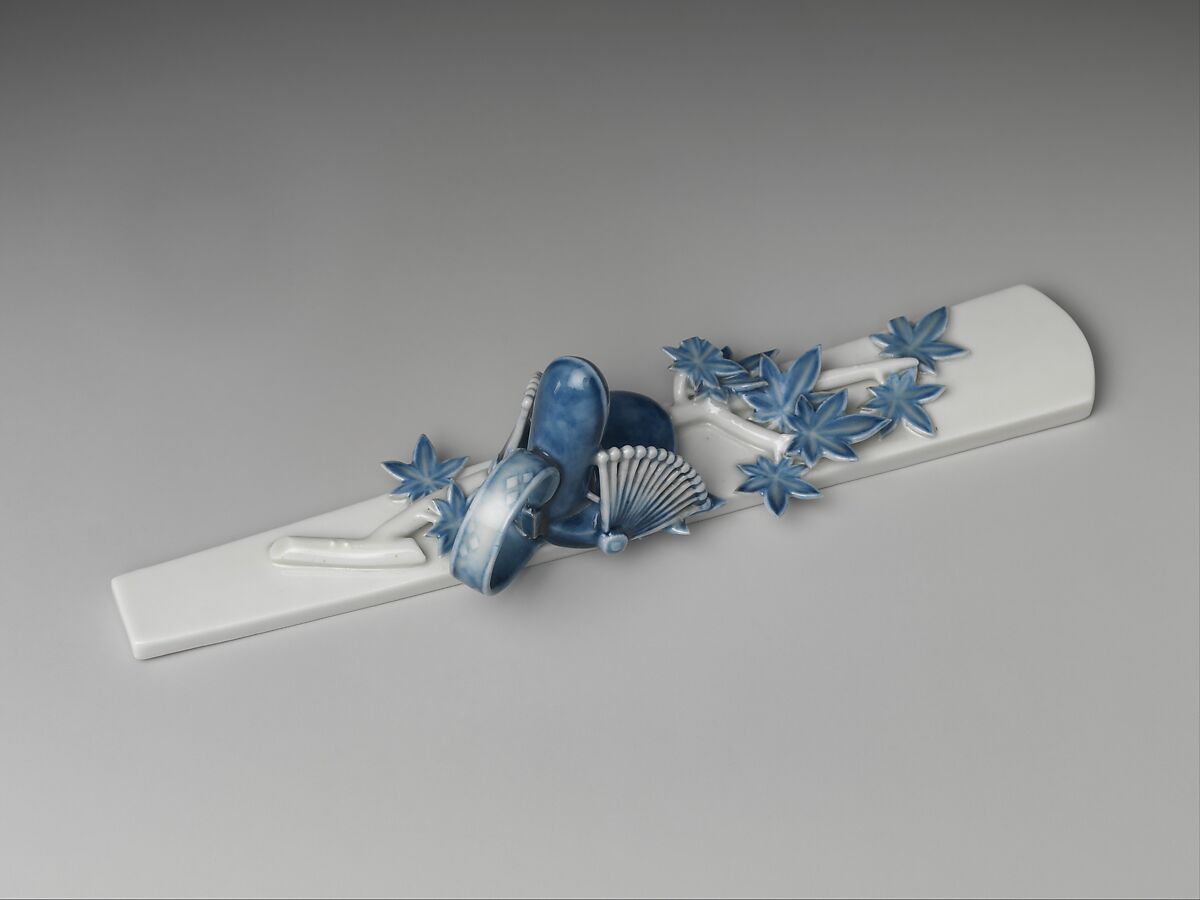 Paperweight (Bunchin) with Maple Branch and Bugaku Hat from “An Imperial Celebration of Autumn Foliage” (Momiji no ga), Chapter 7 of The Tale of Genji, Molded porcelain with cobalt blue under transparent glaze (Mikawachi ware), Japan