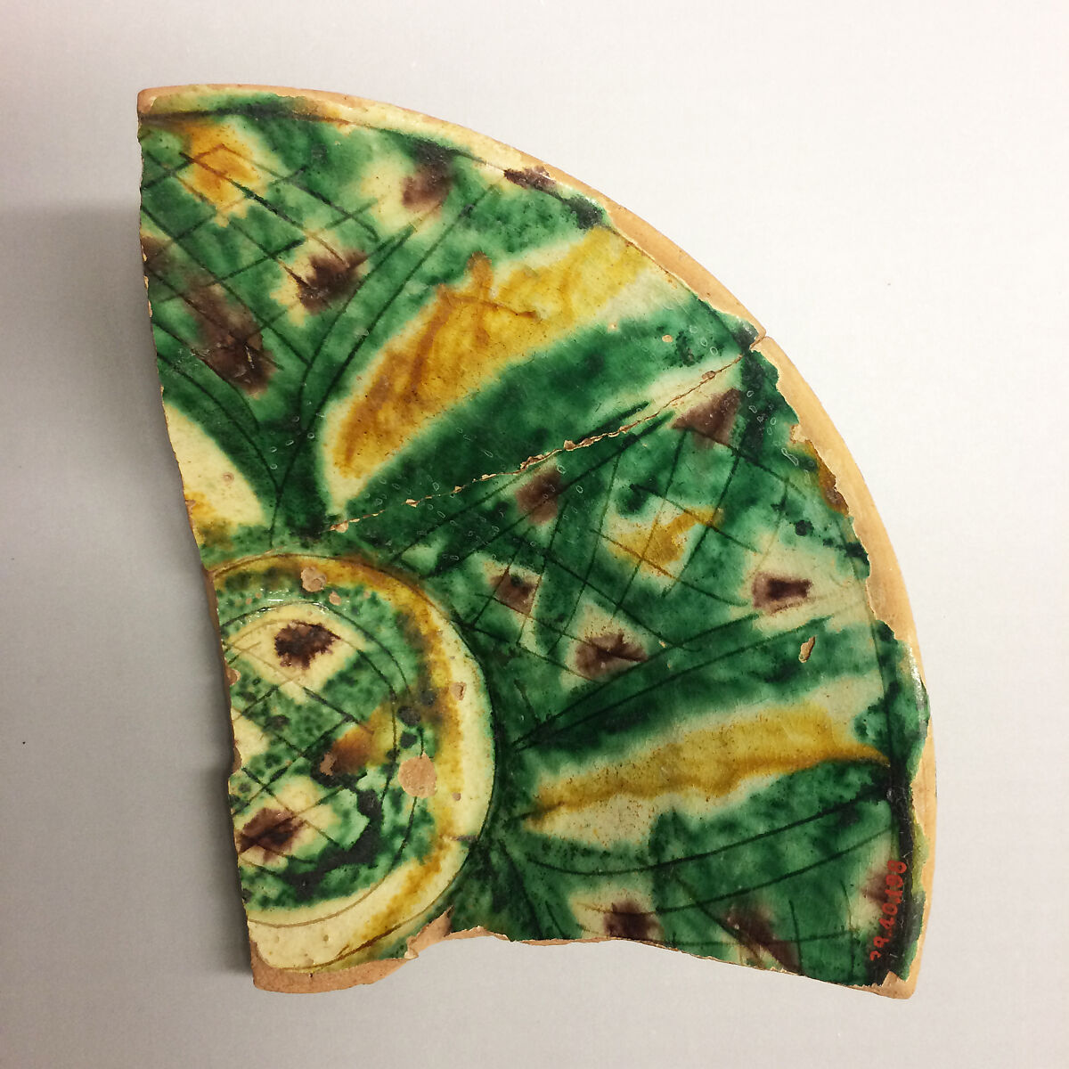 Fragment of a Bowl, Earthenware; white slip with polychrome slip decoration under transparent greenish glaze, incised 