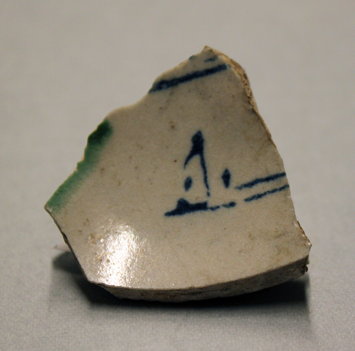 Ceramic Fragment, Earthenware; opaque white glaze, green splashed glaze, inscription in blue