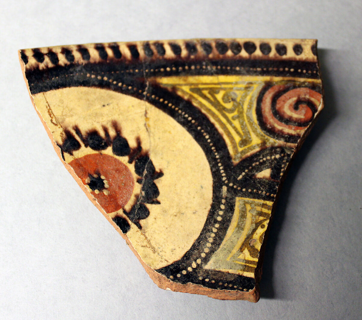 Fragment of a Bowl, Earthenware; red body, white slip with manganese brown, red and yellow-black decoration under glaze 