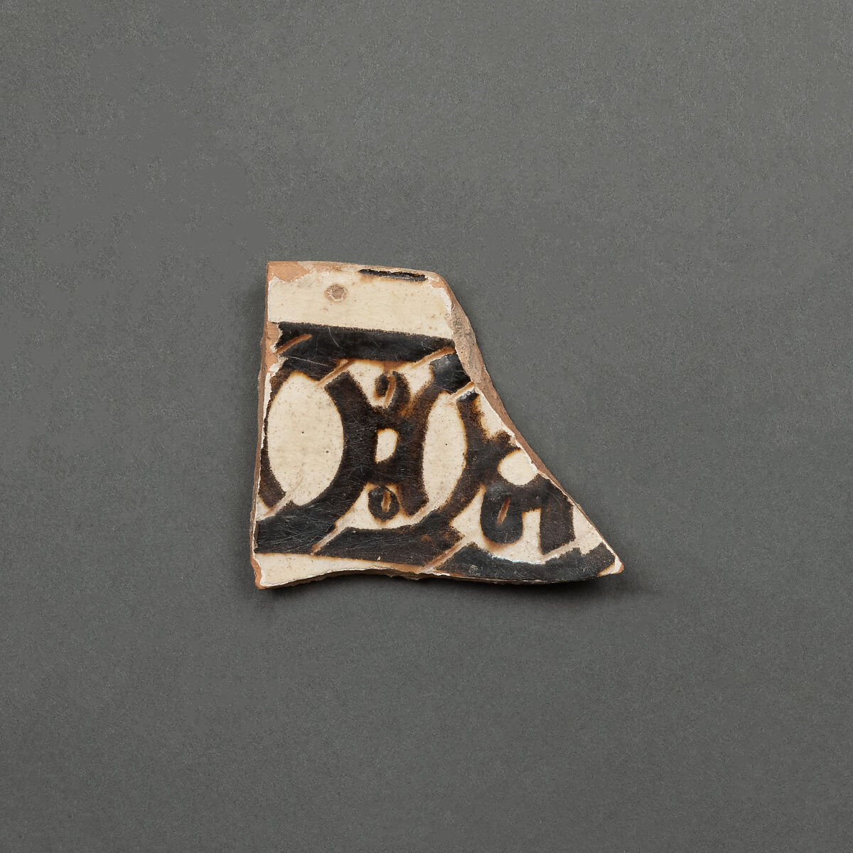 Fragment of a Bowl, Earthenware; red body, white slip, brown-black slip decoration and sgraffito under glaze