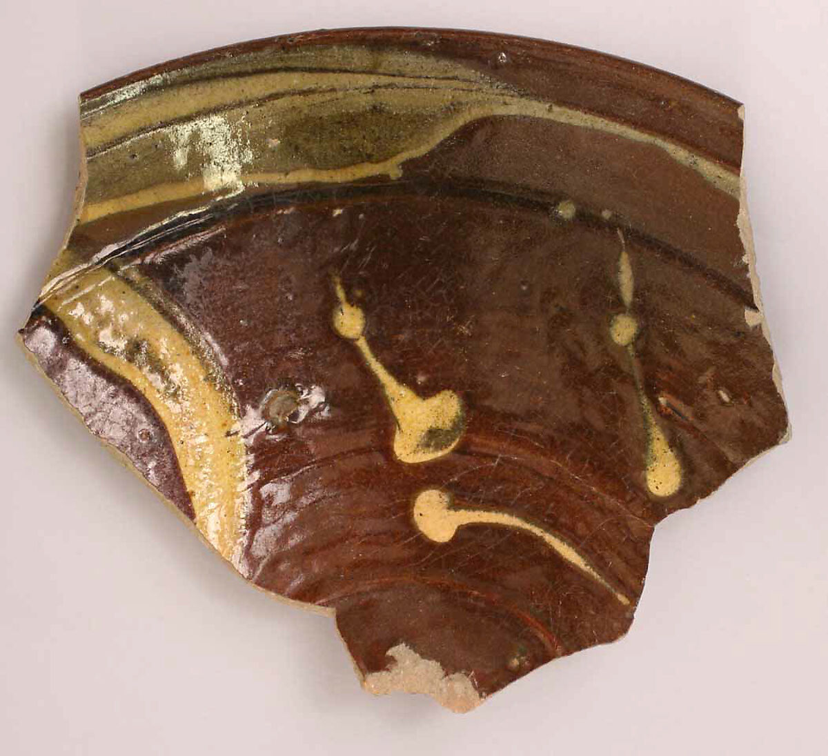 Fragment of a Dish, Earthenware; gritty body, brown and yellow streak decoration under glaze 