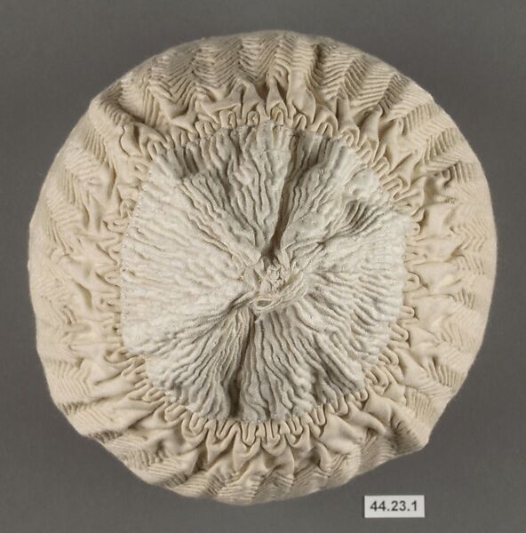 Cap, Cotton; quilted diagonally, border of punch work embroidery edged with crocheted cotton lace