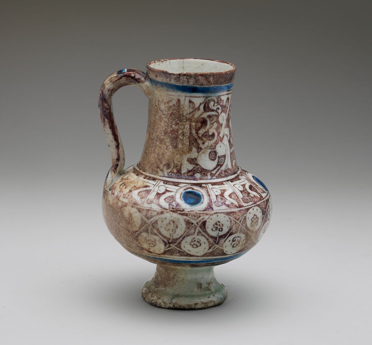 Ewer Inscribed with "al-'izz" ("Glory") in Floriated Kufic on its Neck, Stonepaste; painted in luster and blue on opaque white glaze under transparent glaze