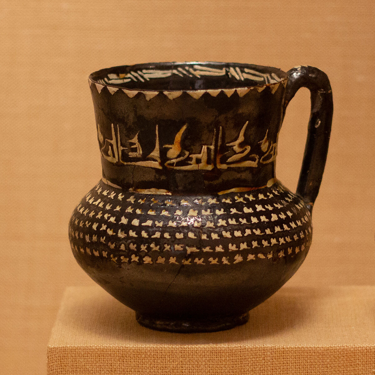 Ewer with Repeated Arabic Phrase, "Blessing", Earthenware; black slip with white slip decoration under transparent glaze 