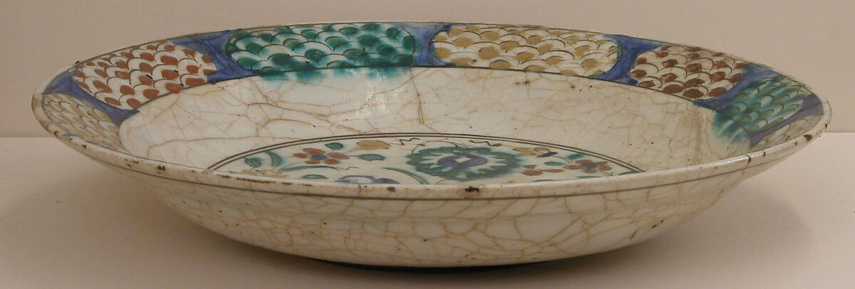 Dish, Stonepaste; underglaze painted in black, blue, and green with red and yellow slips