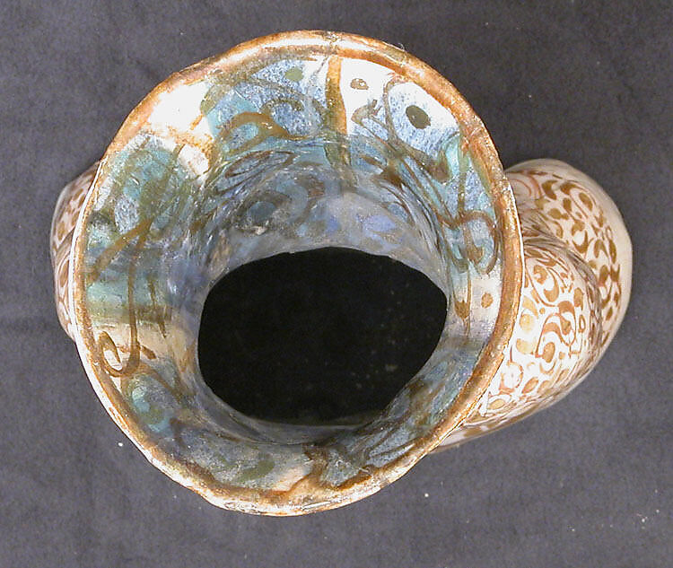 Hollow Vessel in the Shape of a Woman Holding a Child, Stonepaste; molded, luster-painted on an opaque white glaze