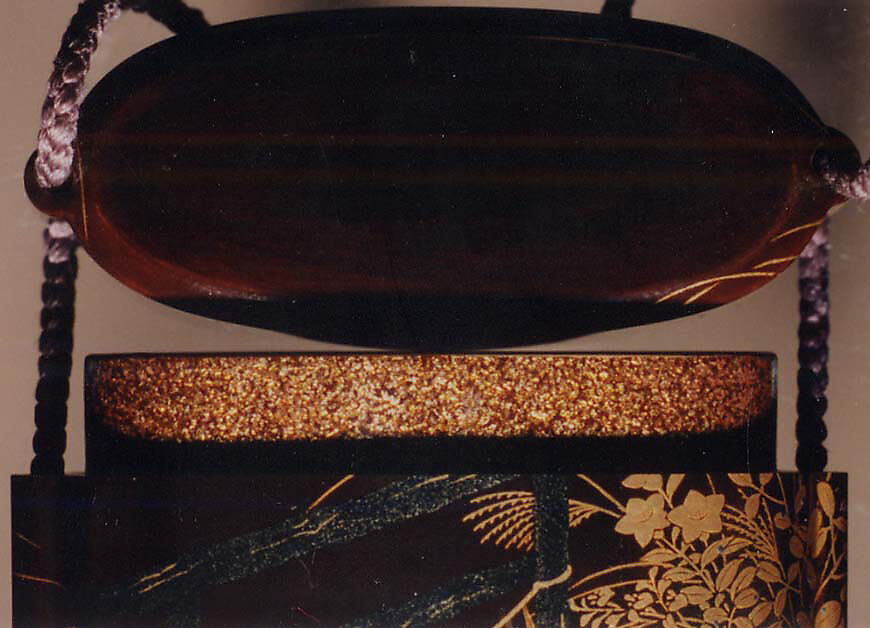 Case (Inrō) with Design of Nonomiya (Shrine in the Fields), from The Tale of Genji, chapter 10, Gold maki-e with black lacquer 
Ojime: bronze with openwork and inlay of water birds on stream 
Netsuke: carved red lacquer, Japan