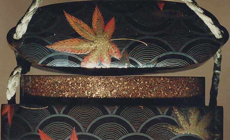 Case (Inrō) with Design of Maple Leaves on Conventionalized Waves, Sprinkled gold and silver lacquer with inlaid mother-of-pearl; ojime is nut carved with dragon motifs; netsuke is dancer carved in wood with ivory bugaku mask; Interior: nashiji, fundame and roiro, Japan