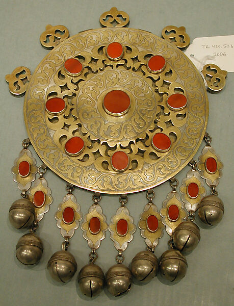 Pectoral Disc Ornament, One of a Pair, Silver; fire-gilded with engraving/punching, stylized floral terminations, openwork decoration, pendants, silver twisted wire chains, table cut carnelians, and bells/beads.