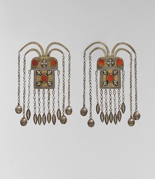 Boy's Amulet, One of a Pair, Silver, fire-gilded with gallery wire, stamped bead and applique decoration, rams' heads upper terminations, link chains, bells, embossed pendants and table cut carnelians 