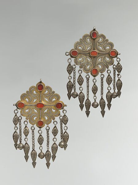 Pair of Floral Pectoral Ornaments, Silver, fire gilded and engraved/punched, stamped and bead decoration with openwork, twisted silver wire chains and pendants with appliques, table cut carnelians and turquoise beads 