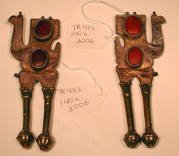 Boy's Amulet in the Shape of Camels, One of a Pair, Silver; fire gilded, with punching, chains, glass stones, and table cut carnelians