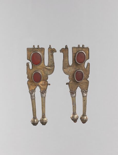 Boy's Amulet in the Shape of Camels, One of a Pair, Silver; fire gilded, with punching, chains, glass stones, and table cut carnelians 
