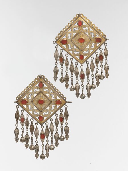 Pair of Pectoral Ornaments, Silver; fire gilded and engraved/punched with openwork, perforated upper terminations, twisted silver wire chains and pendants with appliques, and table-cut carnelians 