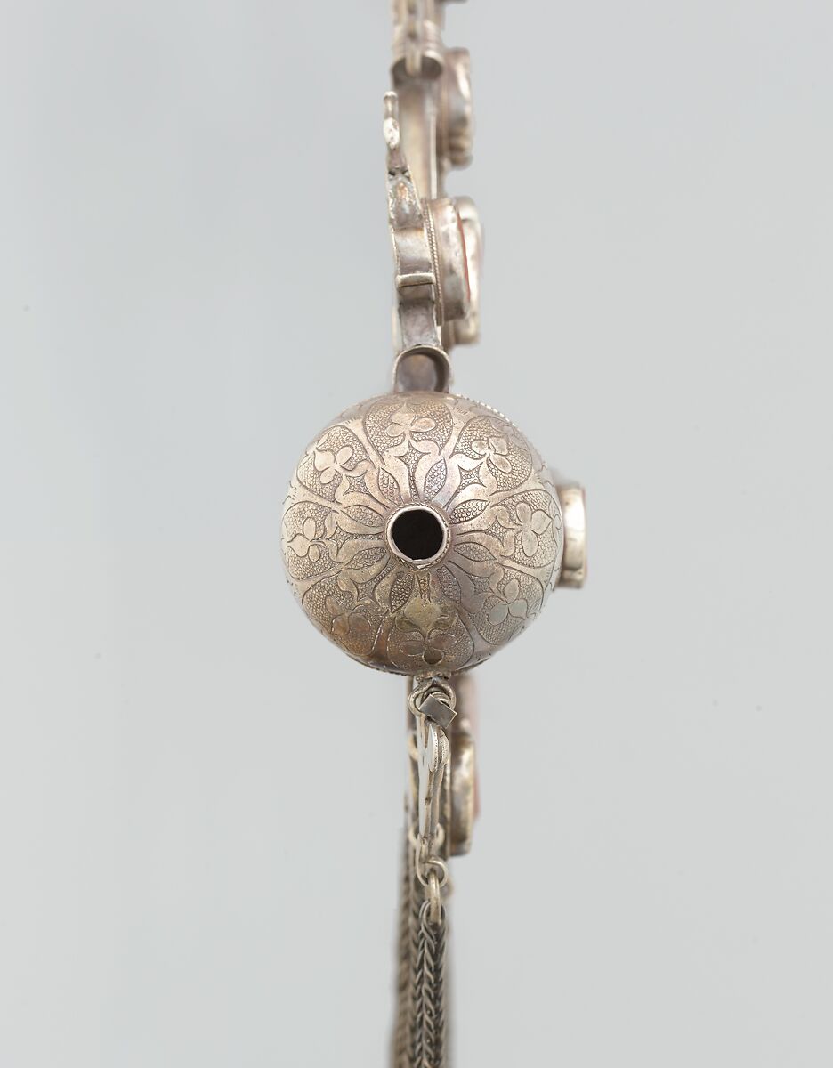Triangular Amulet Holder, Silver; with twisted wire chains and bells, chased and embossed decoration, and table-cut cut carnelians