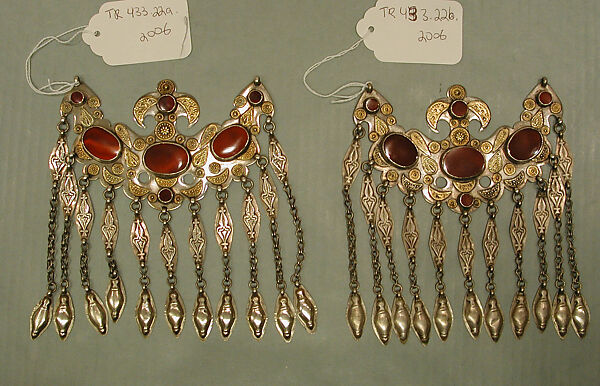 Headdress Ornament, Silver with gilt applique decoration, connecting links with embossed decoration, rams head terminations, silver link chains, and table cut carnelians