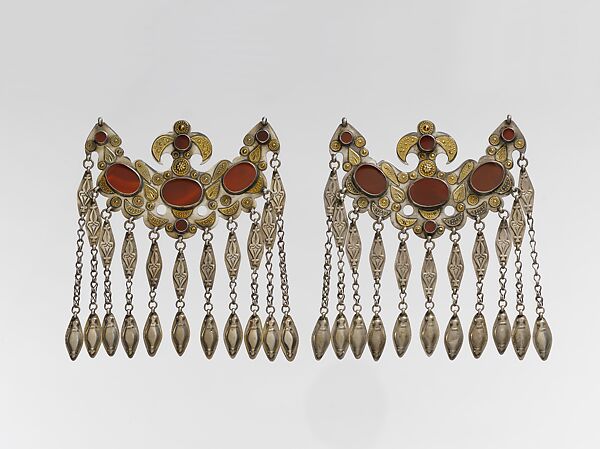 Headdress Ornament, Silver with gilt applique decoration, connecting links with embossed decoration, rams head terminations, silver link chains, and table cut carnelians 