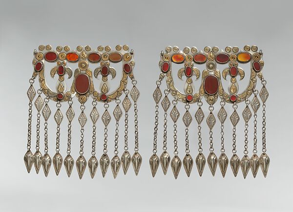 Dorsal Headdress Ornament, One of a Pair, Silver; with gilt applied decoration, connecting links with embossed decoration, ram’s-head terminals, loop-in-loop chains, and table-cut carnelians