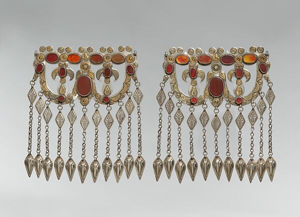 Dorsal Headdress Ornament, One of a Pair, Silver; with gilt applied decoration, connecting links with embossed decoration, ram’s-head terminals, loop-in-loop chains, and table-cut carnelians 