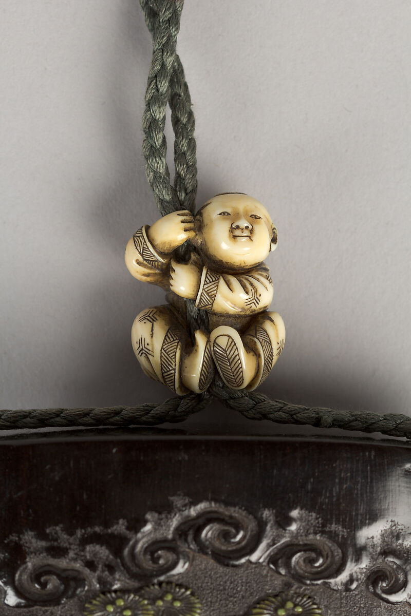 Case (Inrō) with Design of Ōni (Demon) Standing Behind Cloak of Arhat (obverse); Fly Whisk (Hossu) beneath Pine Tree (reverse), Tokoku, Wood ebony, carved relief with inlay of ivory, metal and malachite; Interior: plain;  Netsuke: Jurojin on crane; Ojime: Child climbing rope, Japan
