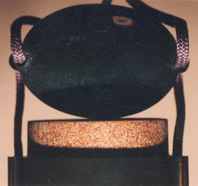 Case (Inrō) with Design of a Suit of Armor (obverse); Flasks for Boys Festival (reverse), Yamada Jōkasai (1681–1704), Gold and colored lacquer with inlaid mother-of-pearl on ro-iro black lacquer; ojime: metal bead inlaid with silver; netsuke: carved ebony inlaid with ivory design of Daruma, Japan