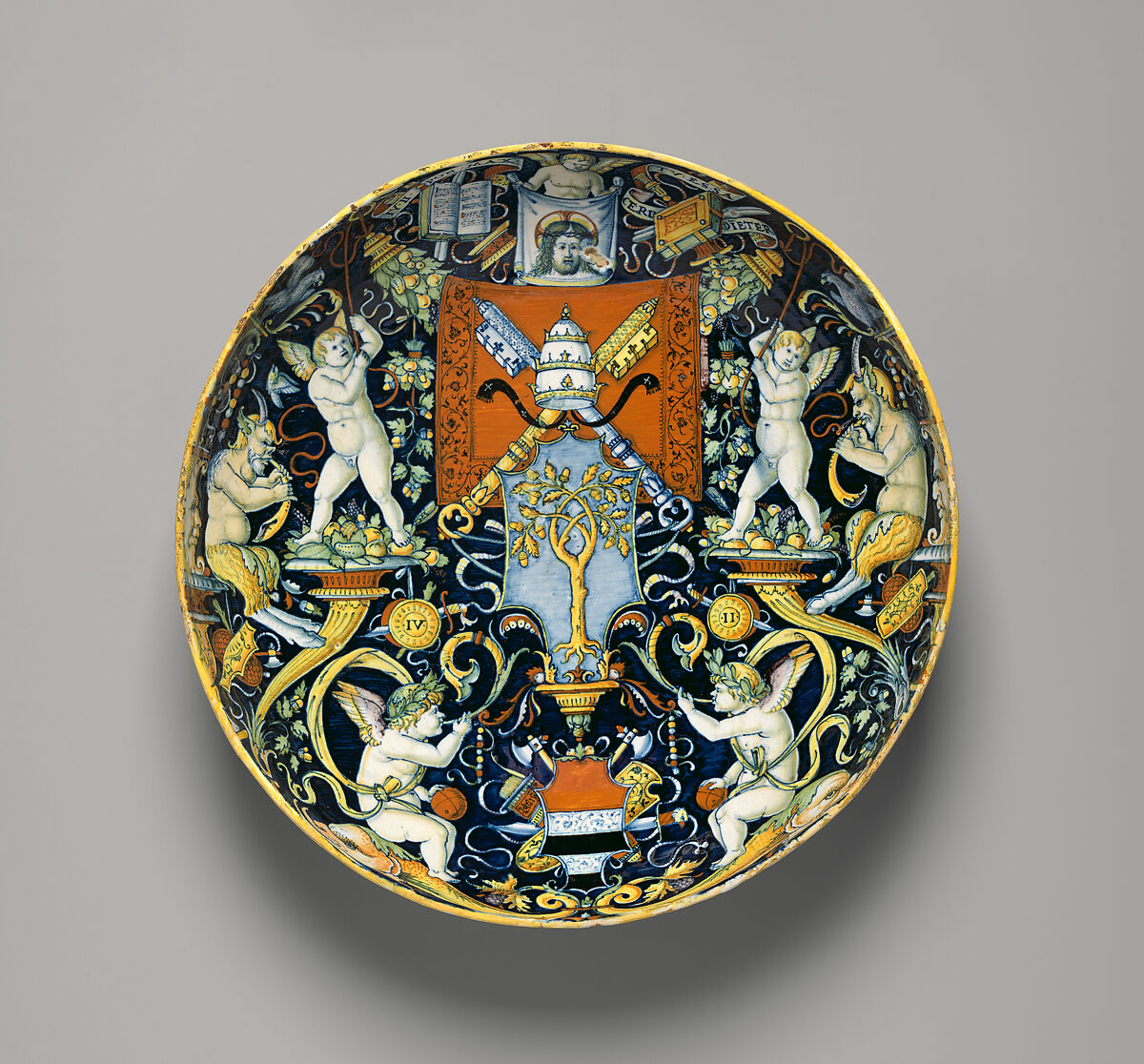 Bowl with the Arms of Pope Julius II and the Manzoli of Bologna surrounded by putti, cornucopiae, satyrs, dolphins, birds, etc., workshop of Giovanni Maria Vasaro (Italian (Castel Durante), active early 16th century), Maiolica (tin-glazed earthenware), Italian, Castel Durante 