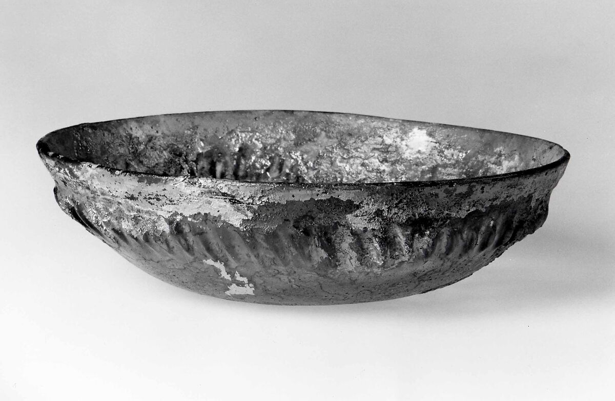 Ribbed bowl, Transparent pale bluish green glass with small spherical bubbles. Cast or poured as a disk, reheated and stamped with a circular mold to form the ribs, then slumped over a former mold to make a bowl; lathe-cut, ground, and polished., Roman 