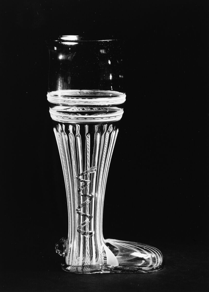 Boot glass, Colorless (slightly tan) and opaque white nonlead glass. Blown, "vetro a retorti", trailed, applied and impressed parts, gilt., Venetian or façon de Venise, probably south Lowlands or Germany