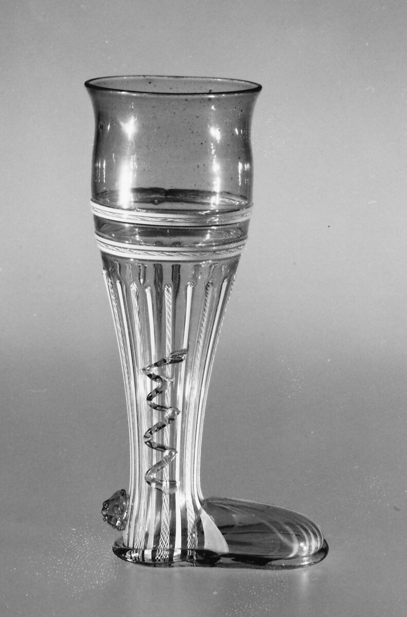 Boot glass, Colorless (slightly tan) and opaque white nonlead glass. Blown, "vetro a retorti", trailed, applied and impressed parts, gilt., Venetian or façon de Venise, probably south Lowlands or Germany