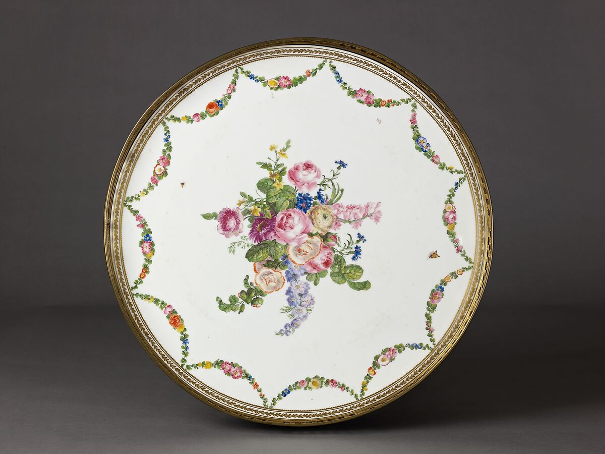 Louis XVI round table with sevres top, Oak veneered with tulipwood, rosewood, green-stained maple, holly stringing; legs veneered with rosewood and partly shaded satinwood; gilt-bronze mounts., French, Paris