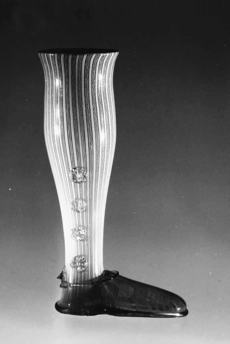 Boot glass, Colorless (gray) and opaque white nonlead glass. Blown, "vetro a retorti", trailed, applied and impressed parts, gilt., Venetian or façon de Venise, probably south Lowlands or Germany