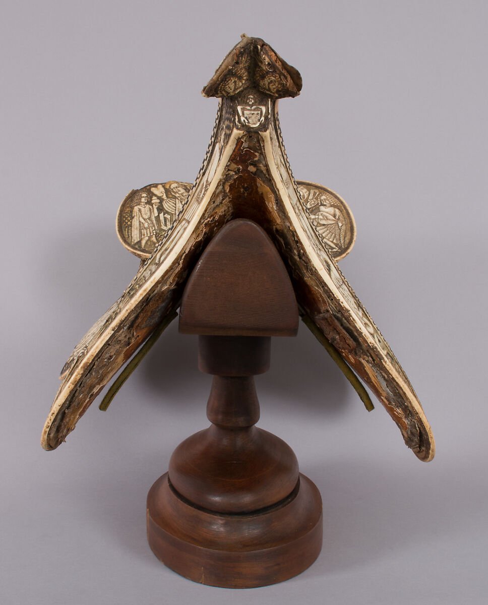 Saddle, Bovine bone (body of saddle), deer antler and bone (decorative elements), limewood, rawhide, birchbark, and metal paint, Central European