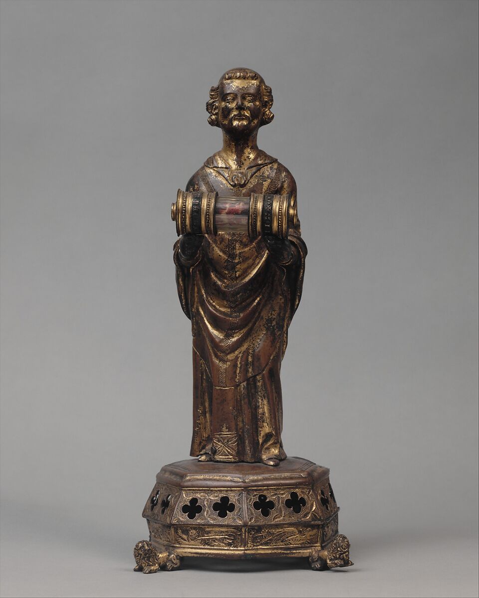 Priest holding a Reliquary, Copper gilt; reliquary vessel: silver, champleve enamel, glass, textile wrapped relic, North French 