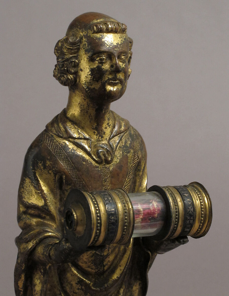 Priest holding a Reliquary, Copper gilt; reliquary vessel: silver, champleve enamel, glass, textile wrapped relic, North French