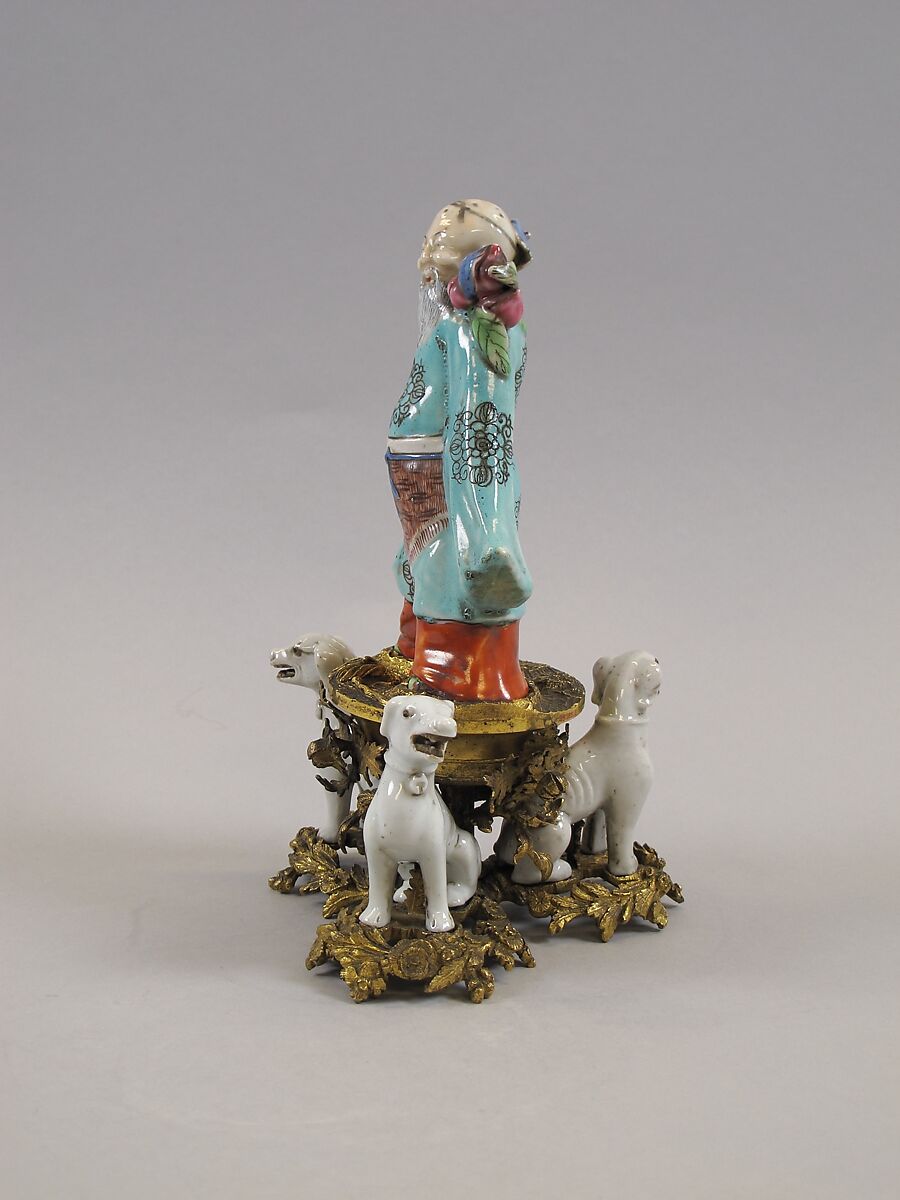 Figure of God of Longevity (Shoulao) and two dogs, Porcelain painted in overglaze polychrome enamels (Jingdezhen ware), European gilt bronze mount, China
