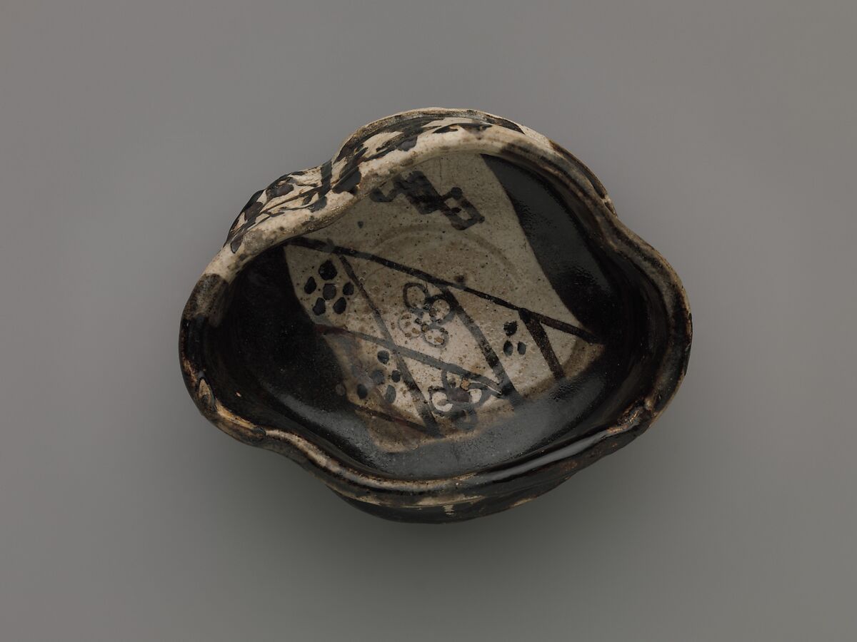 Clog-shaped tea bowl (kutsu-gata chawan) with plum blossoms and geometric patterns, Stoneware with iron-oxide decoration (Mino ware, Black Oribe type), Japan