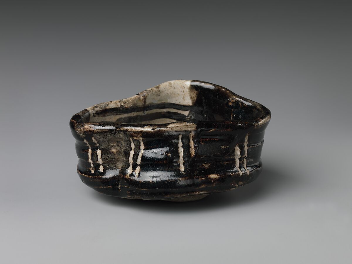 Clog-shaped tea bowl (kutsu-gata chawan) with plum blossoms and geometric patterns, Stoneware with iron-oxide decoration (Mino ware, Black Oribe type), Japan
