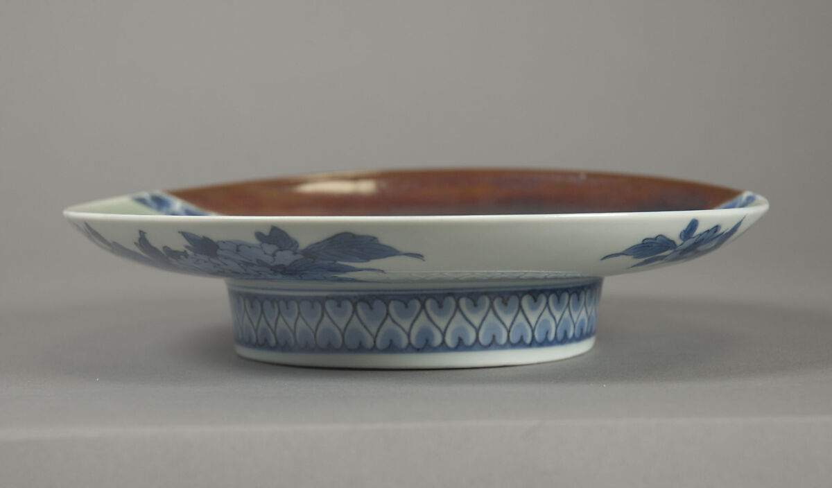 Dish with Cherry Blossoms and Textile Curtains, Porcelain with celadon glaze, partial iron brown glaze, and cobalt blue under transparent glaze (Hizen ware, Nabeshima type) , Japan