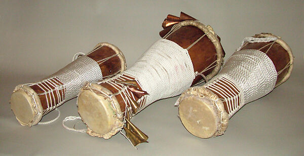 Batá, Brandon Rosser (American, active New York, late 20th century), Sweet maple, polyurethane finish, brass and copper bells, nylon, steel bolts, jet bead, deer skin heads, golden oak stain, red clay, American