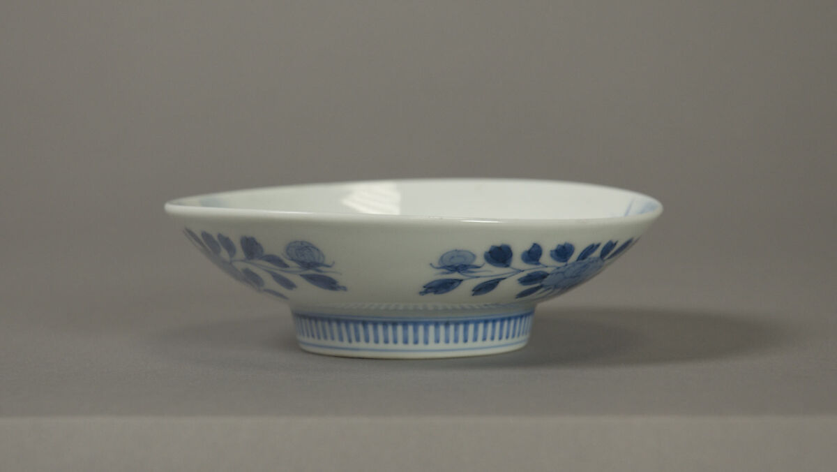 Dish with Fish in a Stream, White porcelain decorated with blue under the glaze; comb pattern round the high foot (Nabeshima ware), Japan