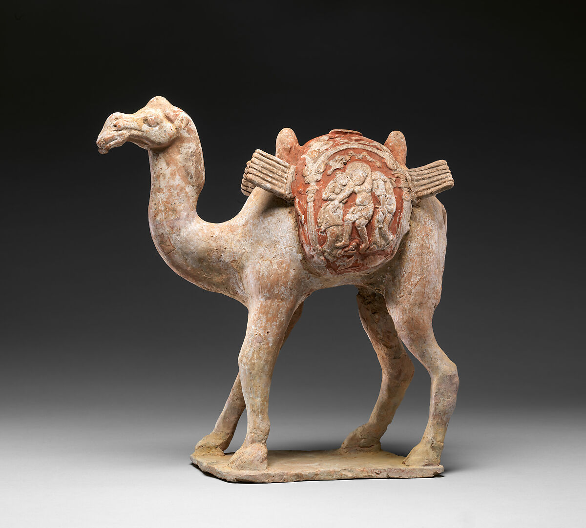 Camel with Dionysian imagery on its saddle bags, Earthenware with appliqué relief decoration and pigment, China 