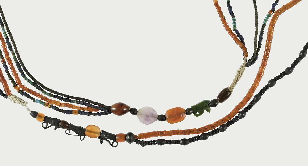 A Necklace of four strands of beads and amulets, Turquoise, amethyst, carnelian, Egyptian blue, faience, silver, plant resin