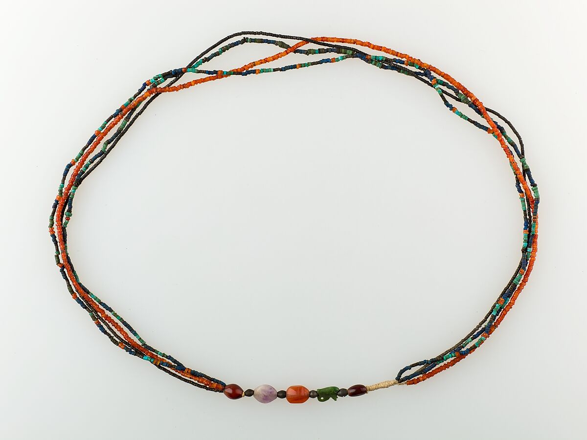 A Necklace of four strands of beads and amulets, Turquoise, amethyst, carnelian, Egyptian blue, faience, silver, plant resin 