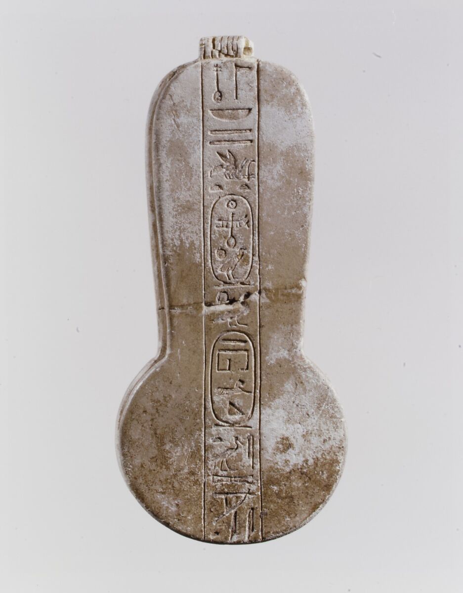 Counterweight of a <em>menit</em> necklace with an image of Bastet nursing King Taharqo, Faience