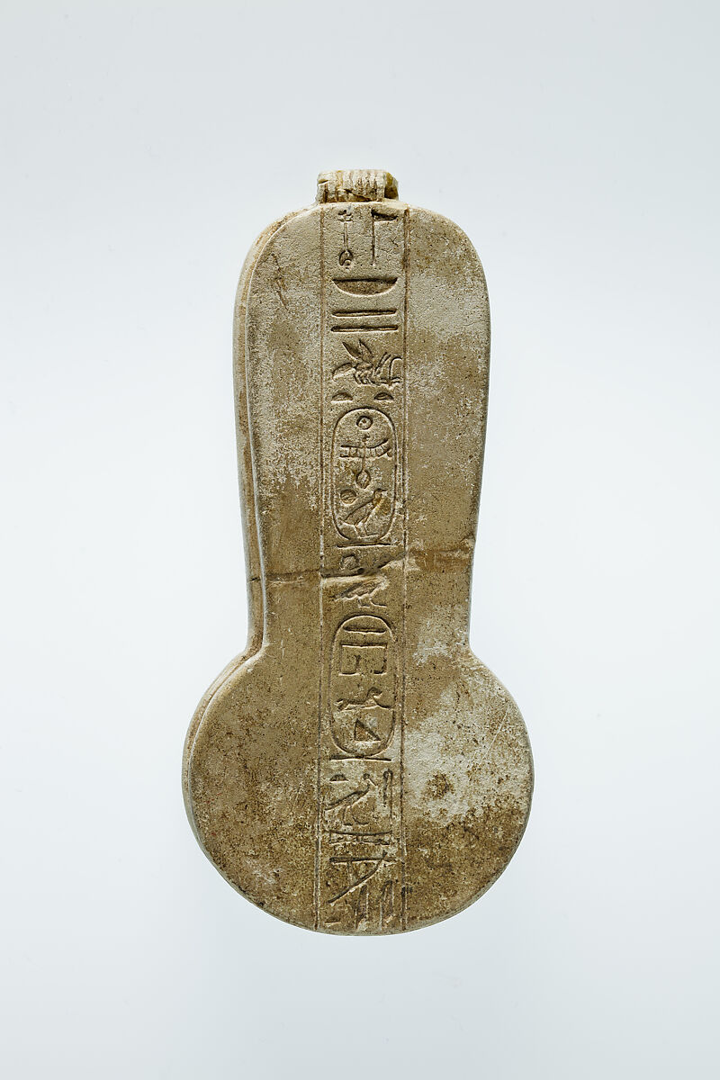 Counterweight of a <em>menit</em> necklace with an image of Bastet nursing King Taharqo, Faience
