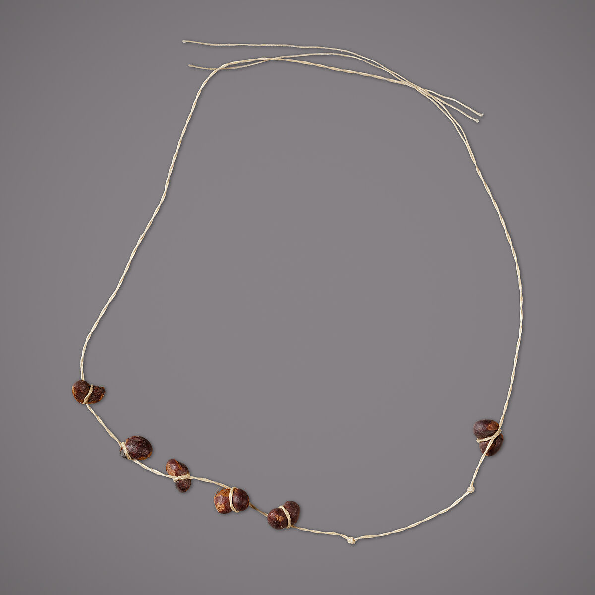 String of 8 kidney-shaped seeds, Seeds, linen string 