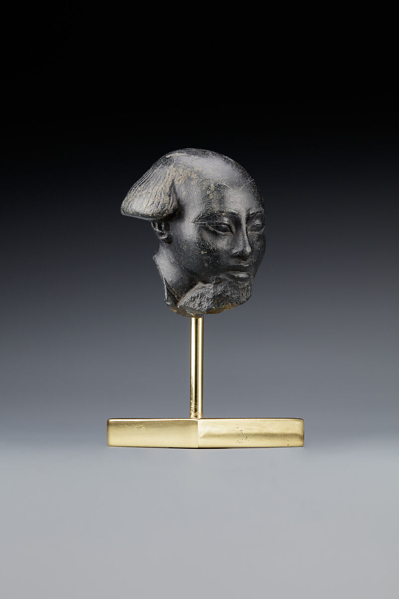 Head fragment from a statuette depicting a "Bald one of Hathor" priest, Steatite