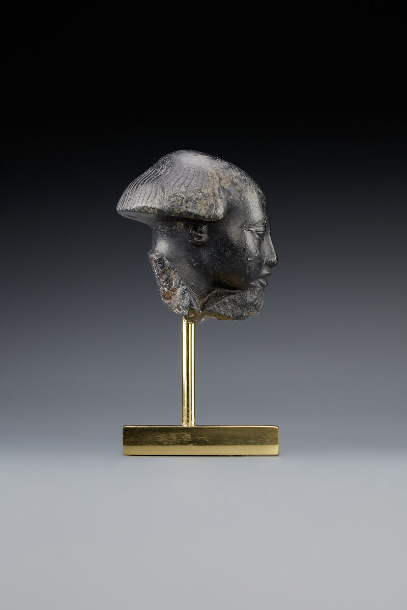 Head fragment from a statuette depicting a "Bald one of Hathor" priest, Steatite